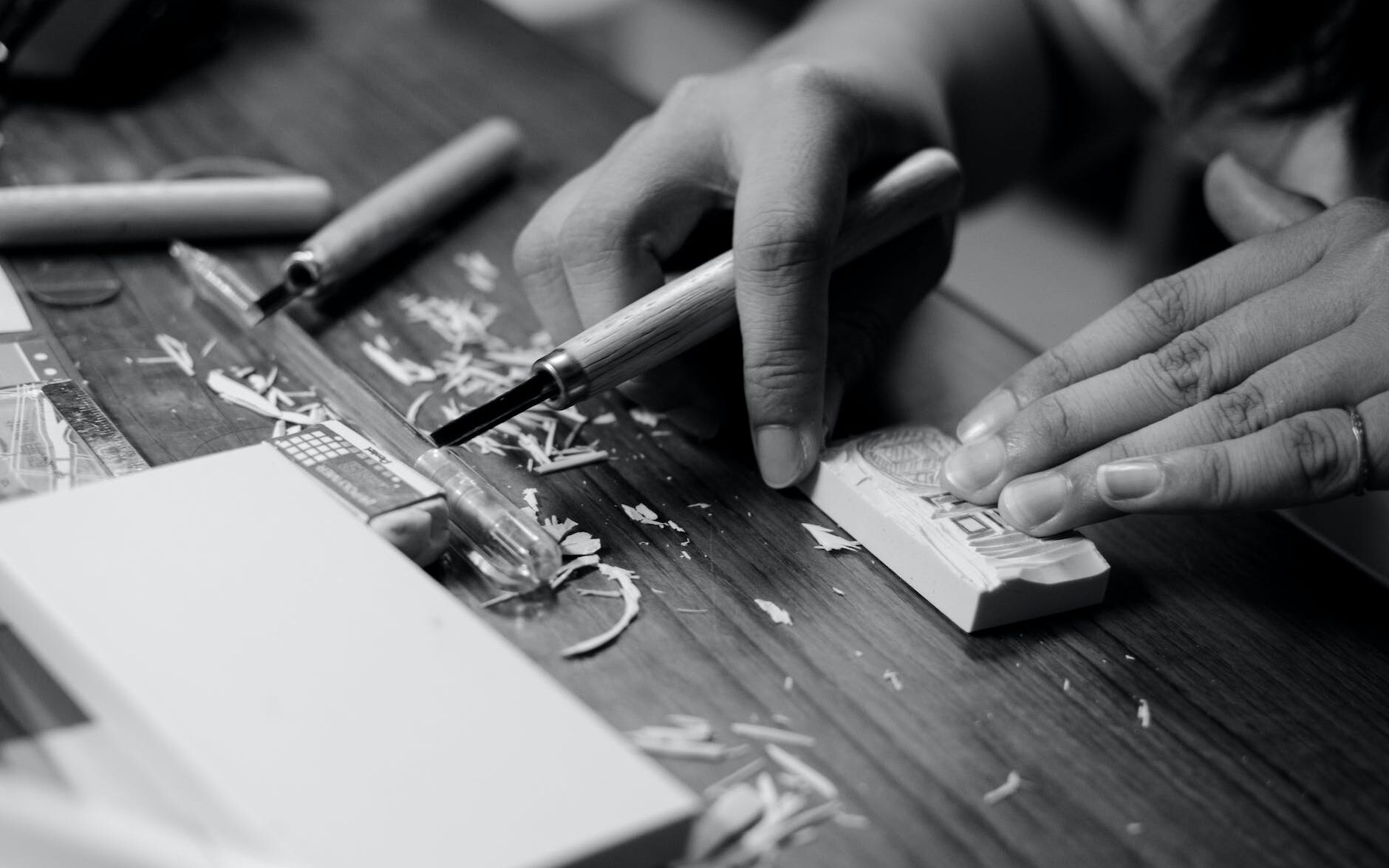 grayscale photo of person carving block